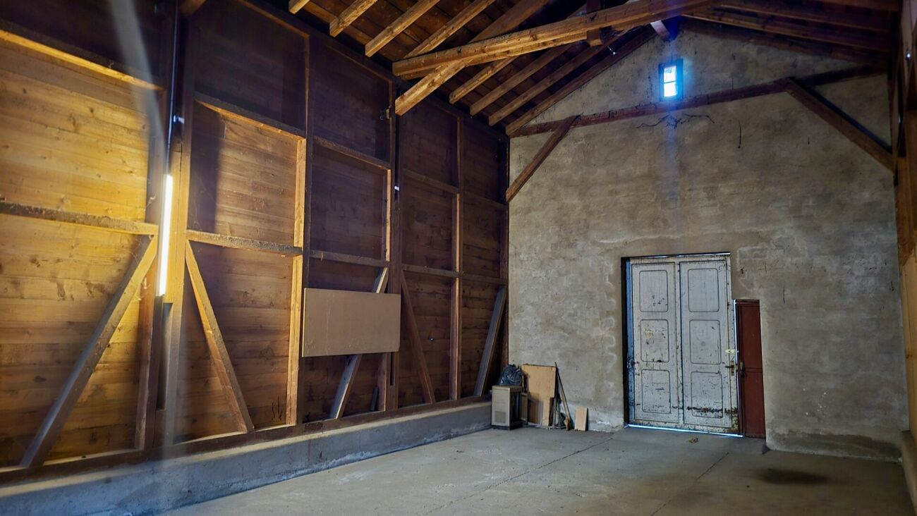 Rustikaler Innenraum mit Holzbalken und Betonboden