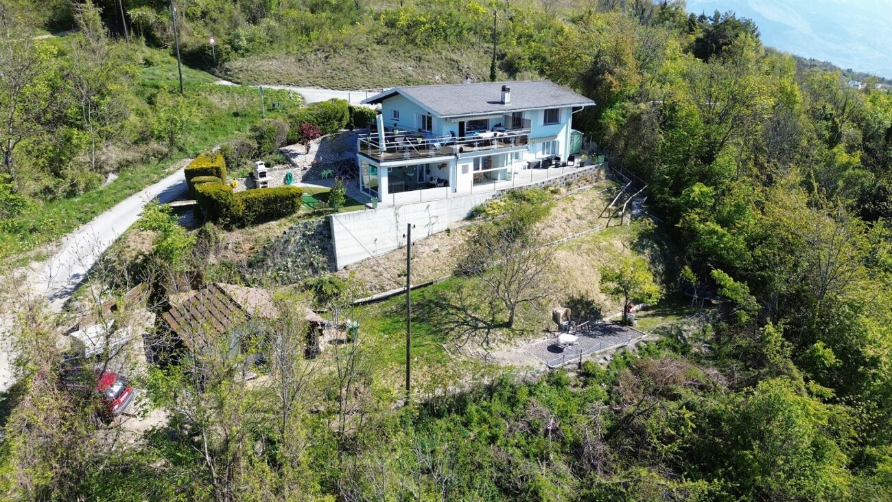 Luftaufnahme eines Hauses mit großem Garten und Hanglage