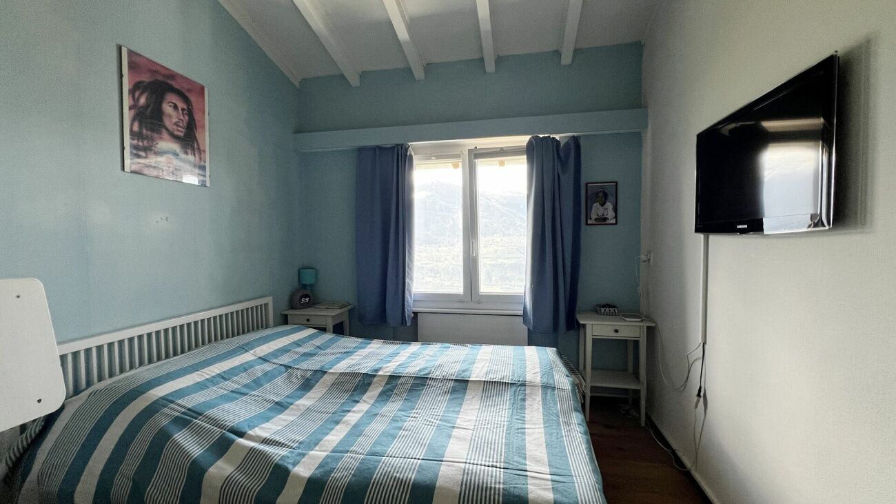 Schlafzimmer mit Doppelbett und Fernseher