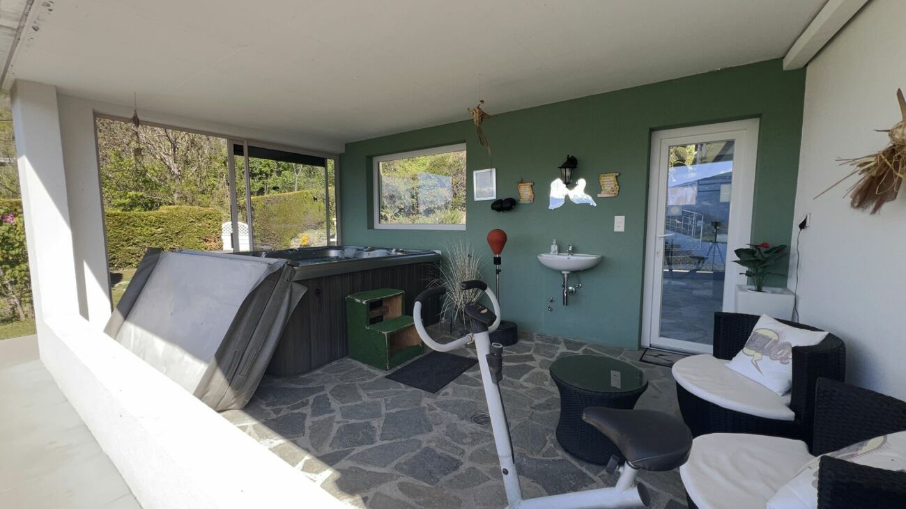 Überdachte Terrasse mit Whirlpool und Sitzbereich