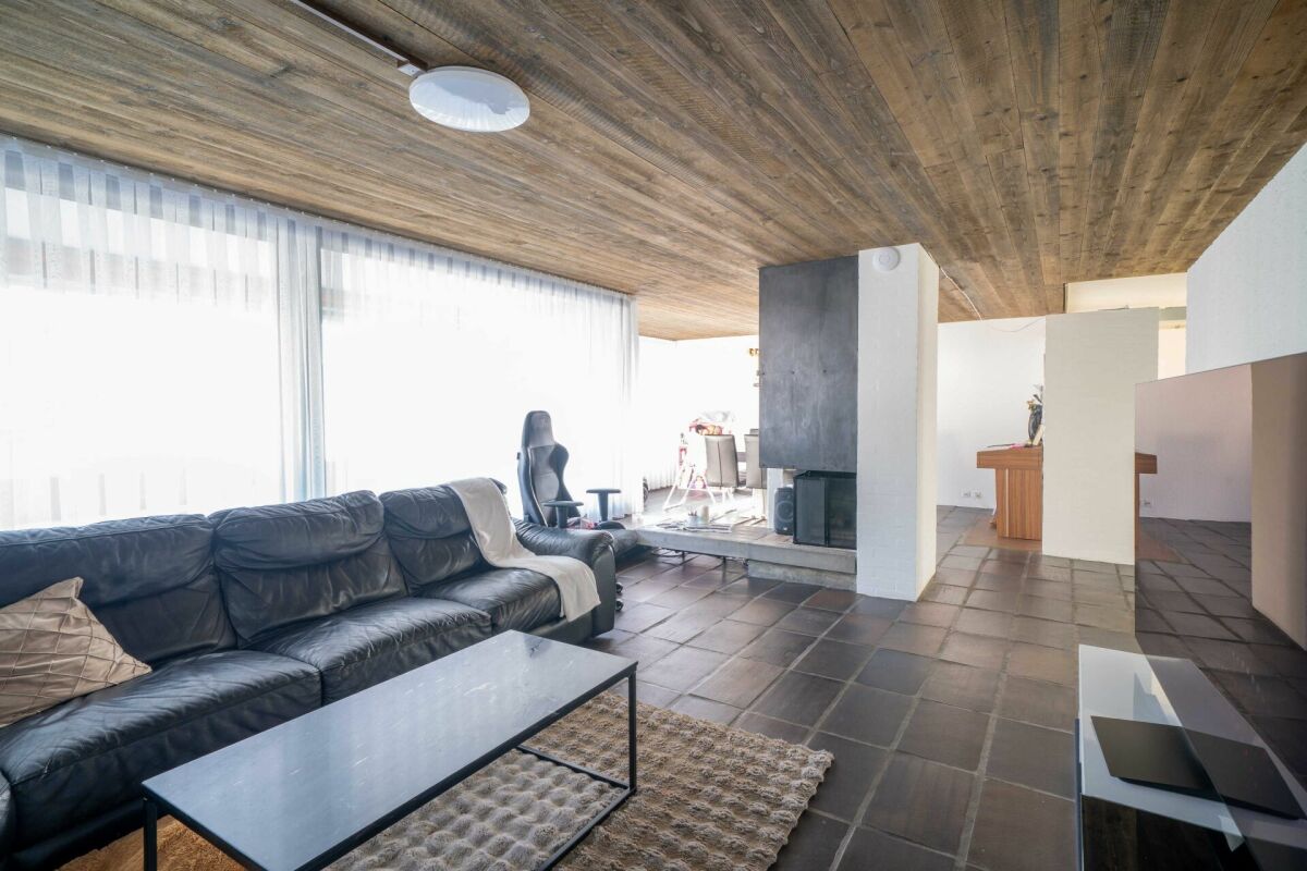 Offener Wohnbereich mit Kamin und Holzdecke