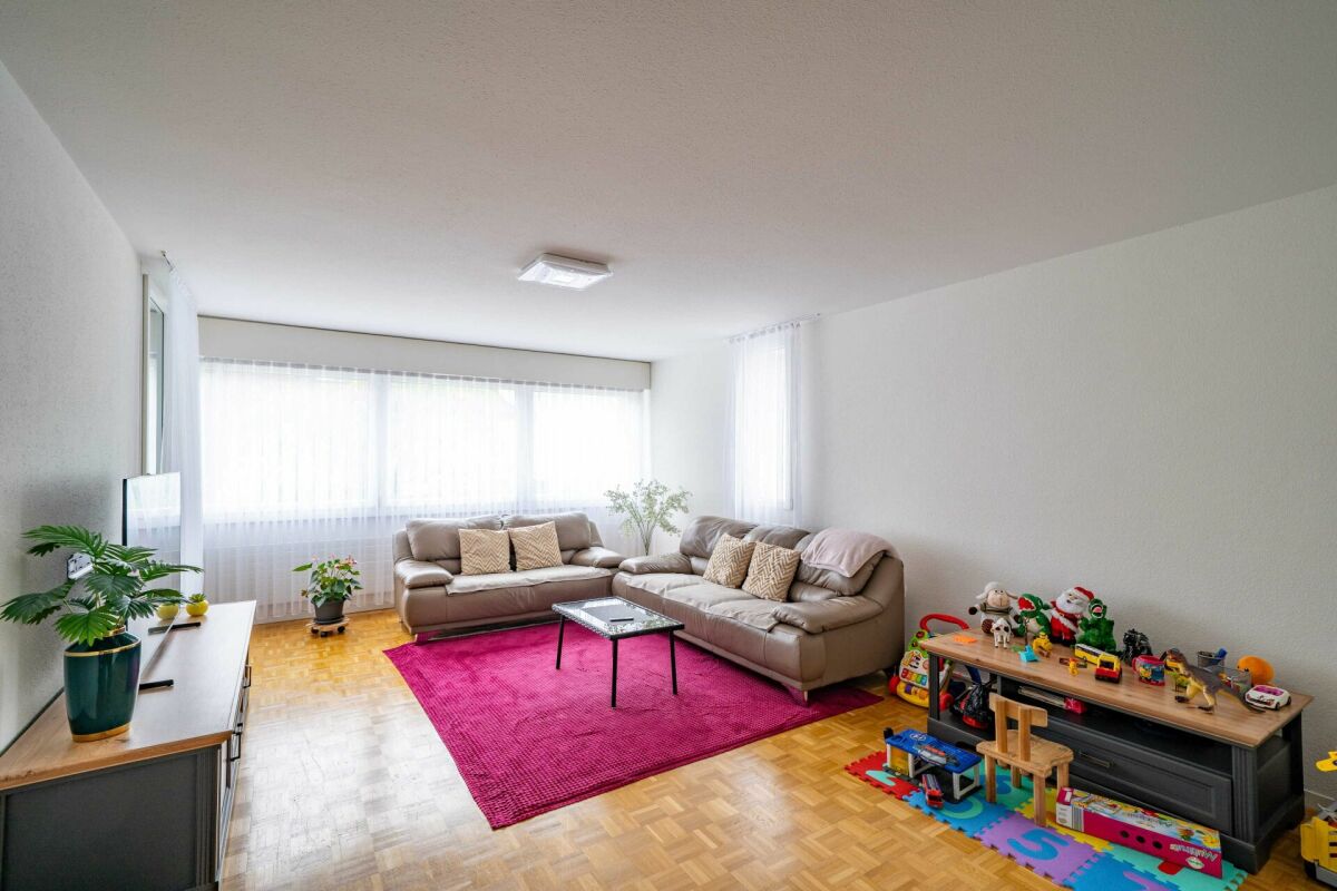 Helles Wohnzimmer mit großer Fensterfront und Spielbereich
