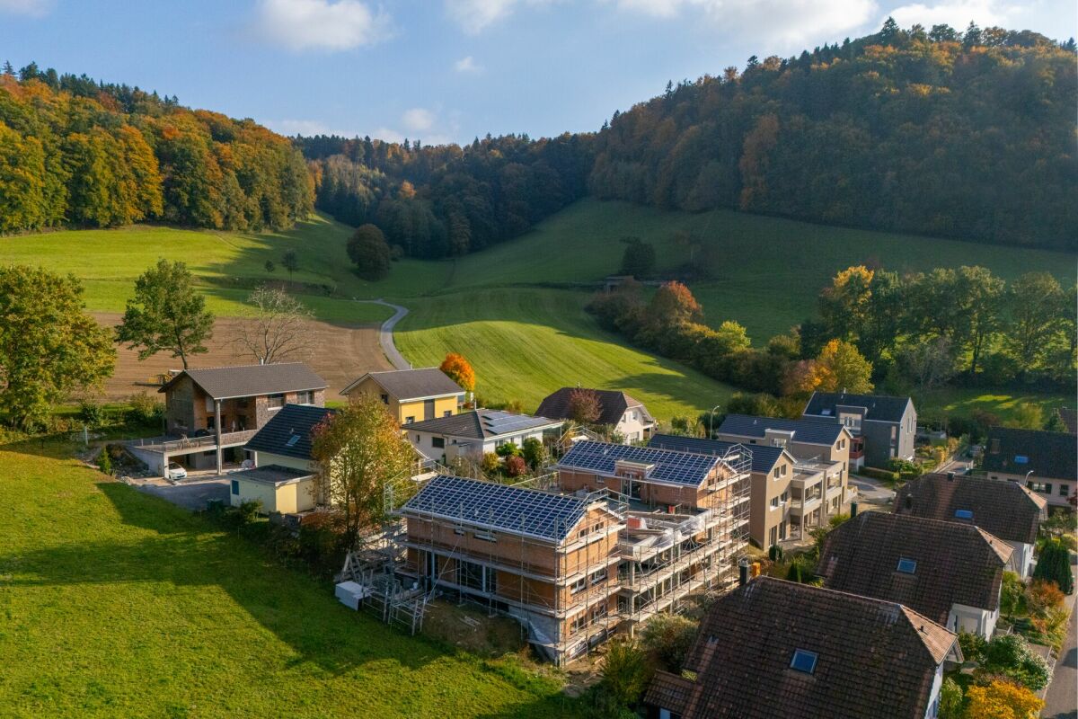Luftaufnahme eines ländlichen Wohngebiets mit Häusern und Hügelblick