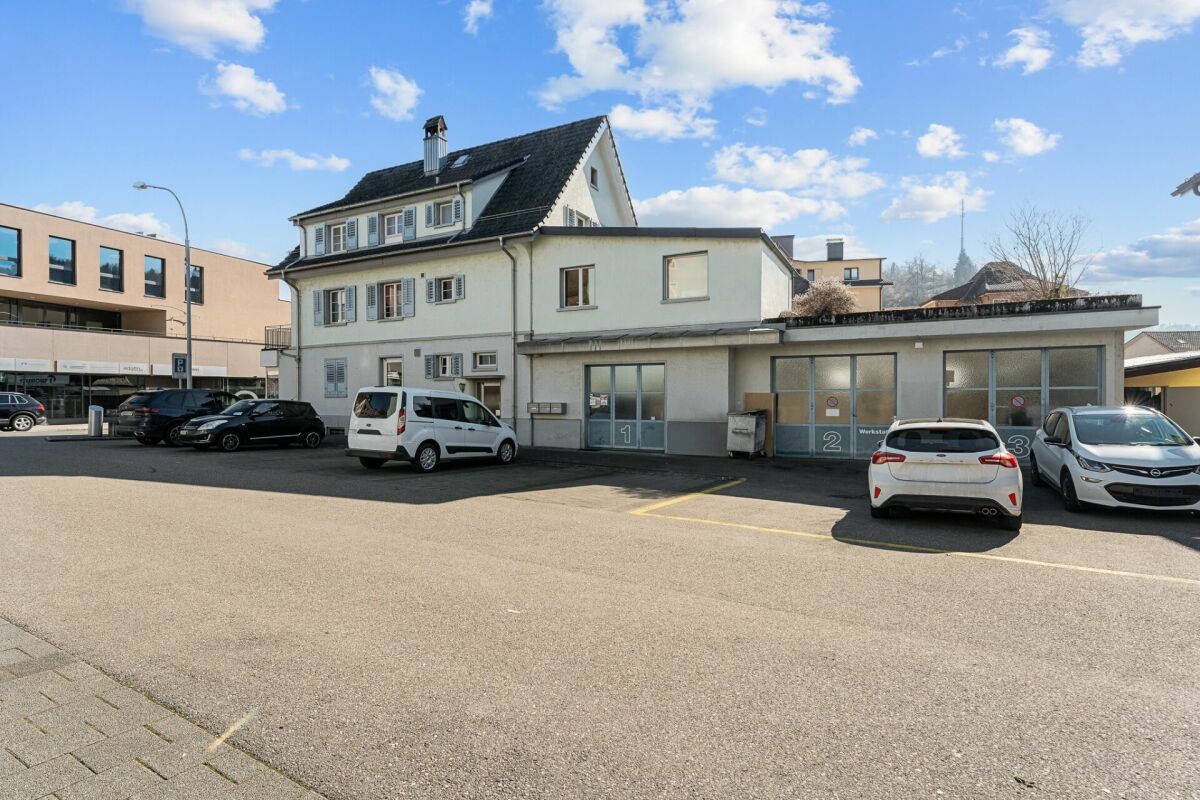 Außenansicht eines Wohn- und Gewerbegebäudes mit Parkplatz