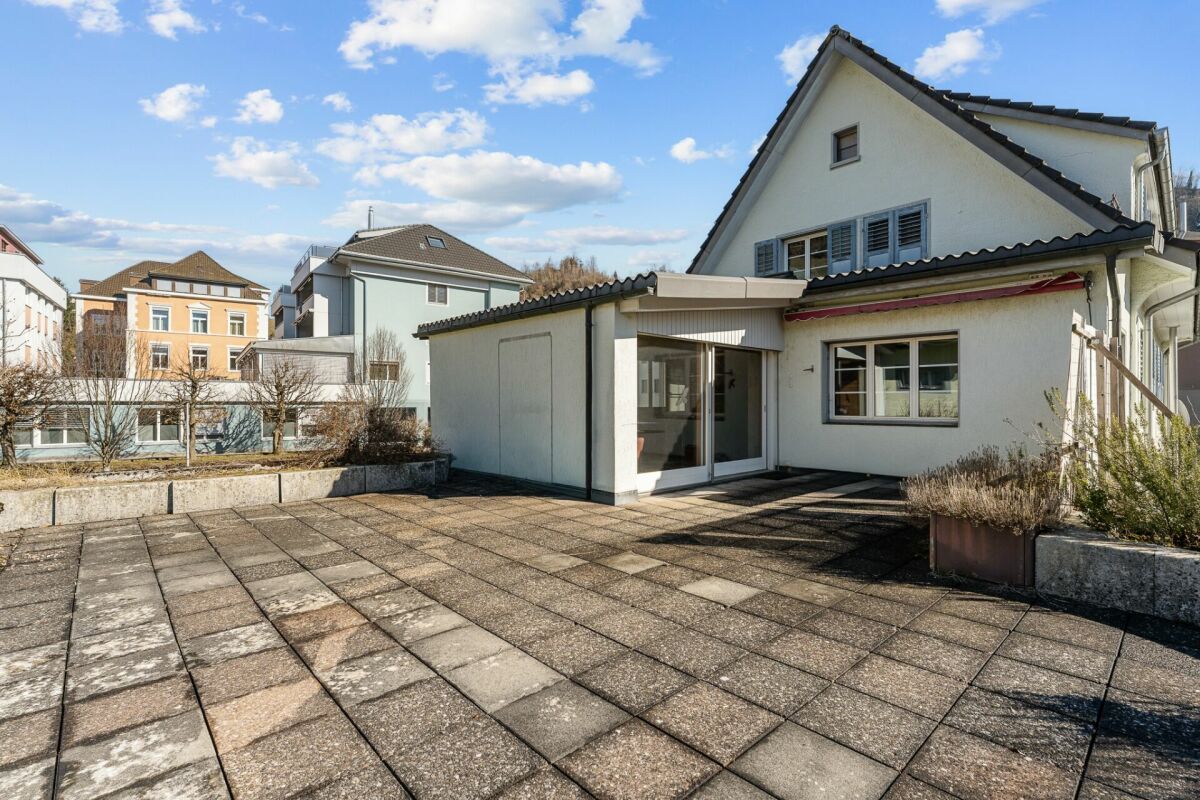Außenansicht eines Hauses mit gepflasterter Terrasse