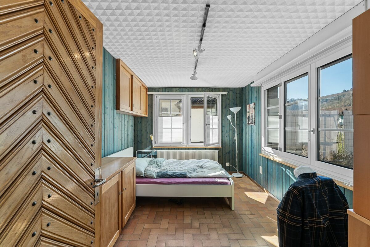 Schlafzimmer mit Fensterfront und Holzvertäfelung