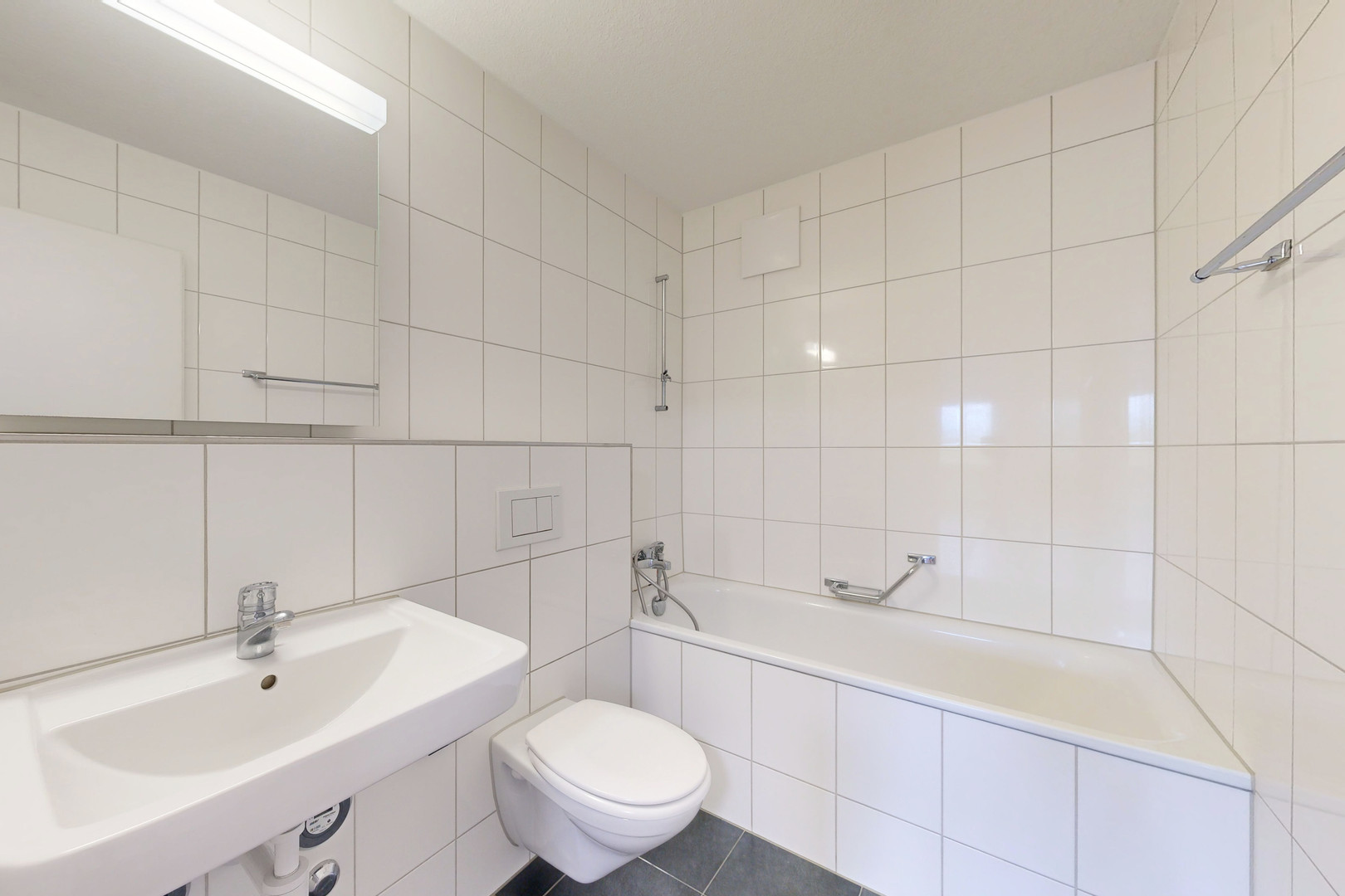Helles Badezimmer mit Badewanne und Wand-WC