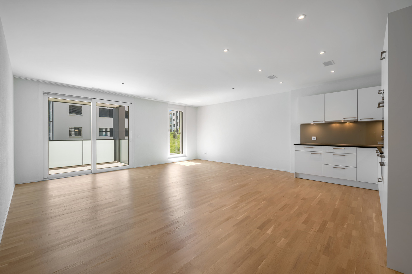 Heller Wohnbereich mit offener Küchenzeile und Balkon