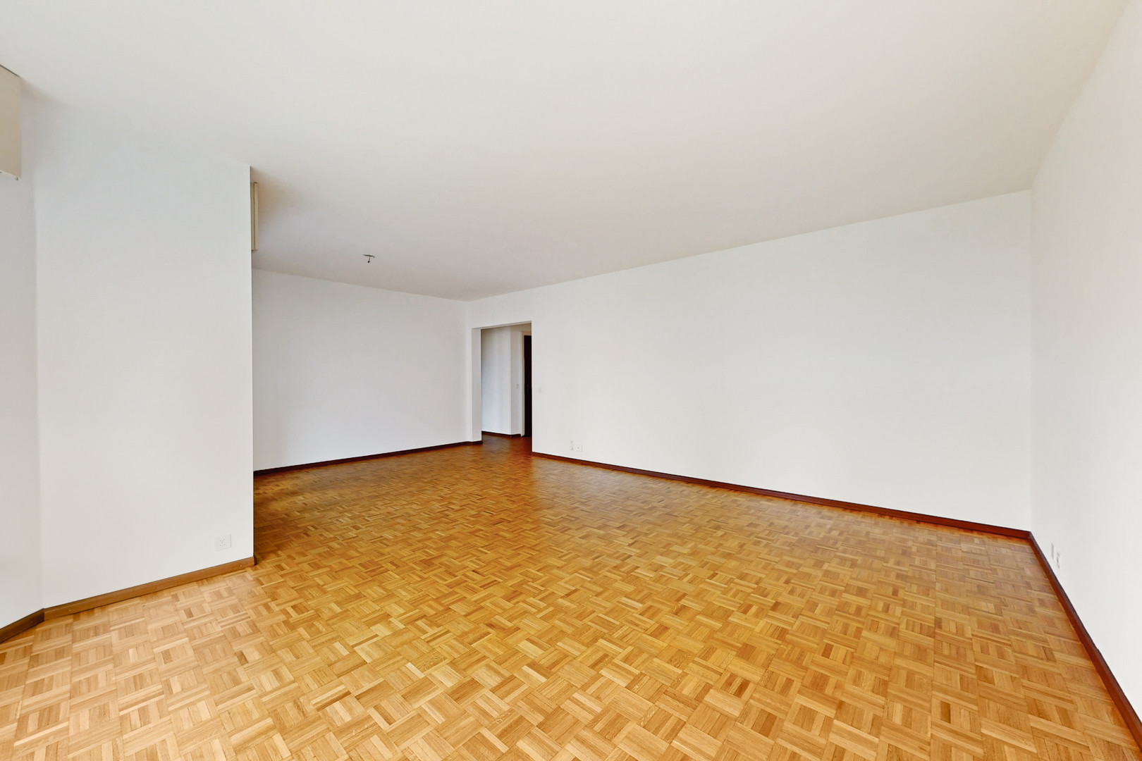 Leerer Wohnraum mit Parkettboden