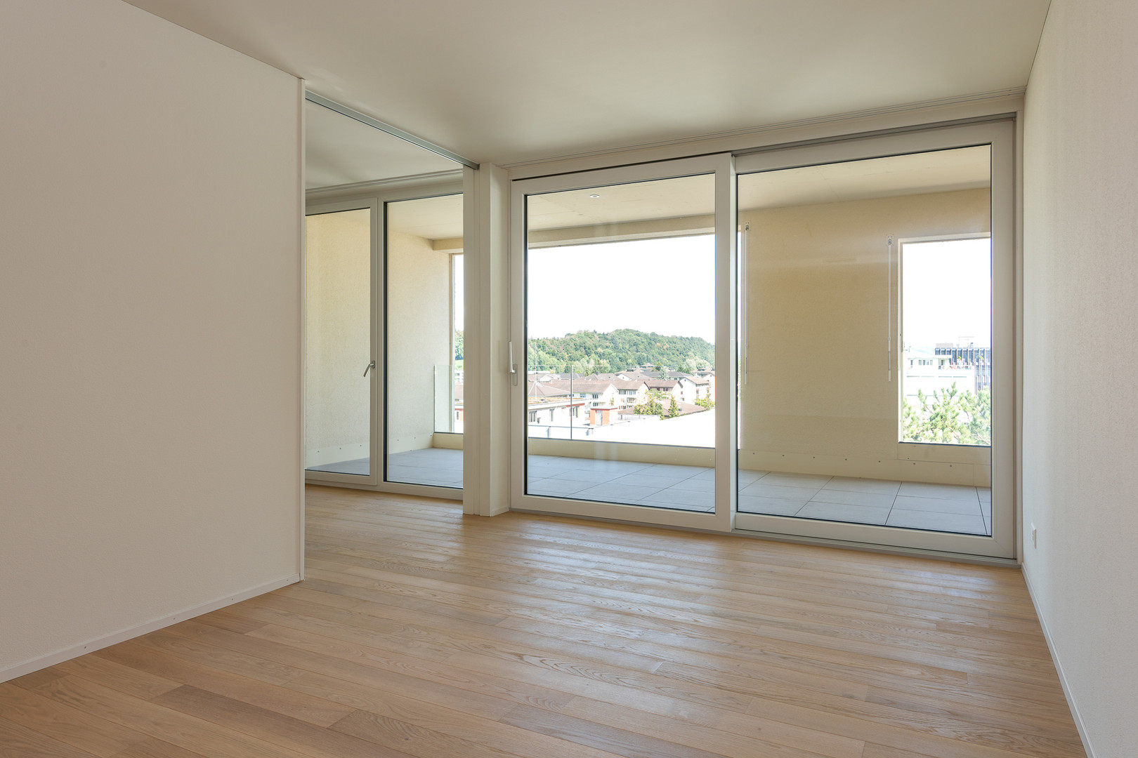 Helles leeres Zimmer mit Balkon und Blick ins Grüne