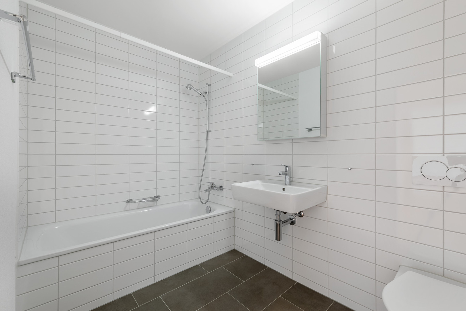 Modernes, weiß gefliestes Badezimmer mit Badewanne