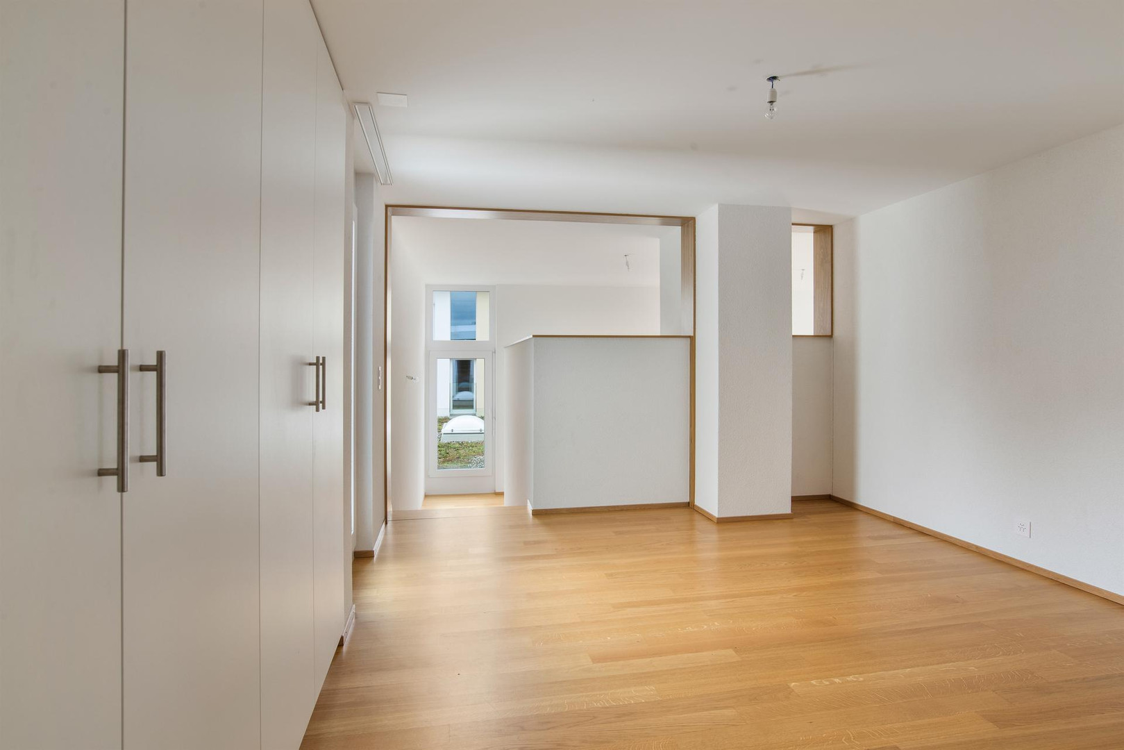 Heller leerer Innenraum mit Holzboden und Einbauschrank