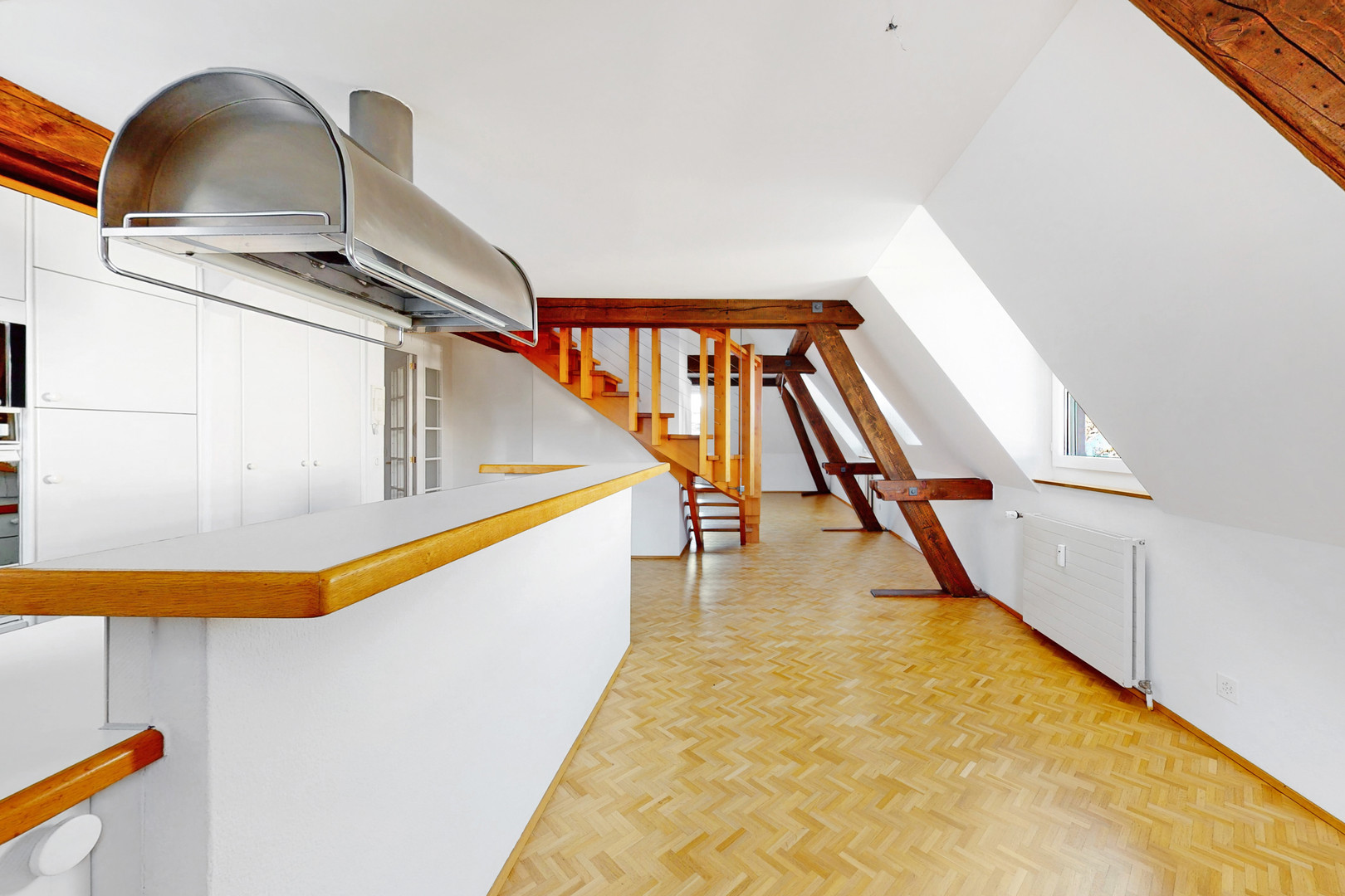 Dachgeschoss mit Treppe und sichtbaren Holzbalken