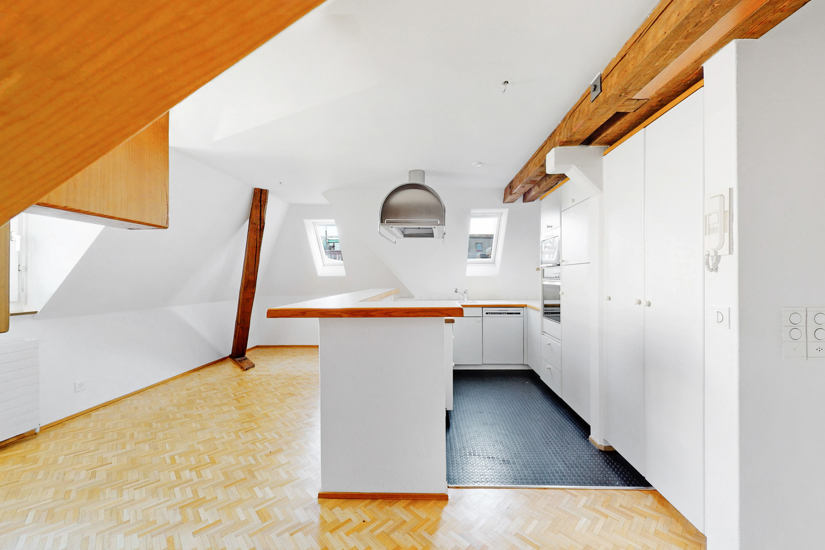 Helle Dachgeschossküche mit sichtbaren Holzbalken
