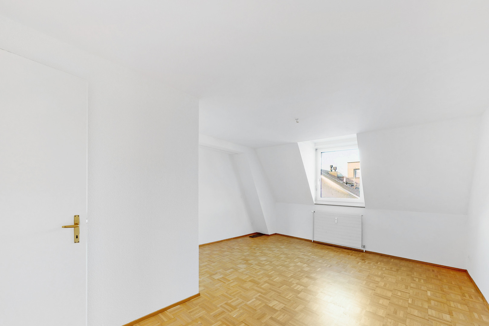 Heller leerer Dachraum mit Parkettboden und Fenster