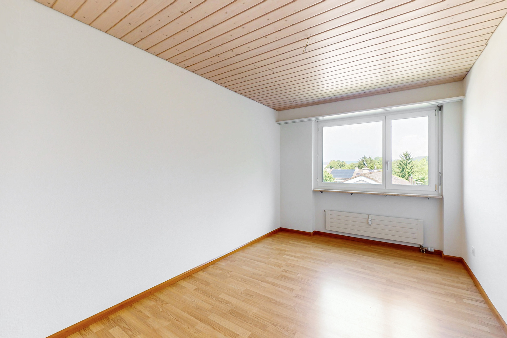 Heller leerer Raum mit Holzdecke und Fenster