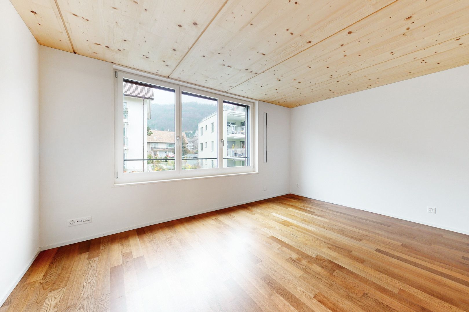 Heller leerer Raum mit Holzdecke und Dielenboden