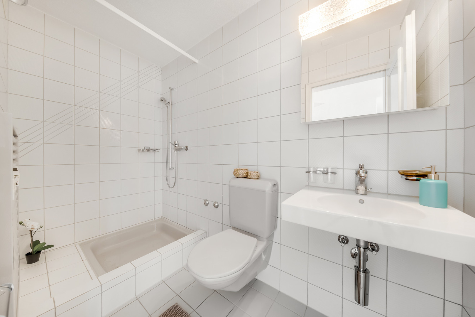 Helles Badezimmer mit Badewanne, wandhängendem WC und Waschtisch