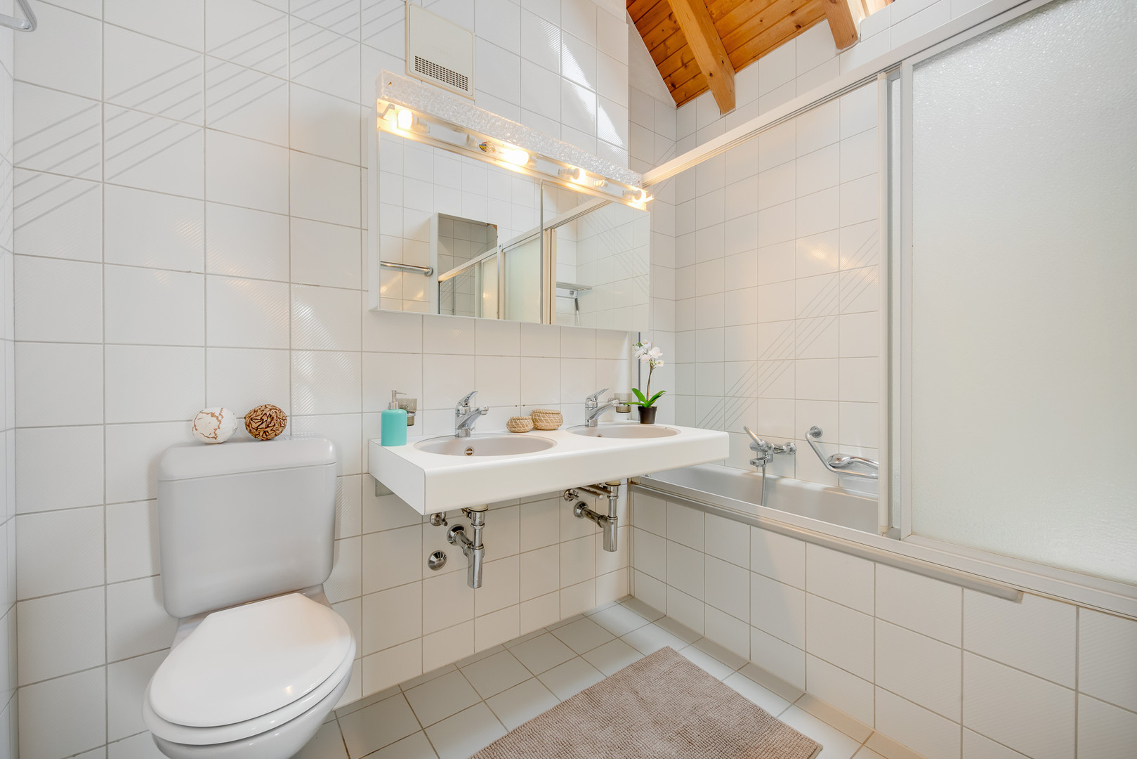 Helles Badezimmer mit Doppelwaschtisch und Badewanne