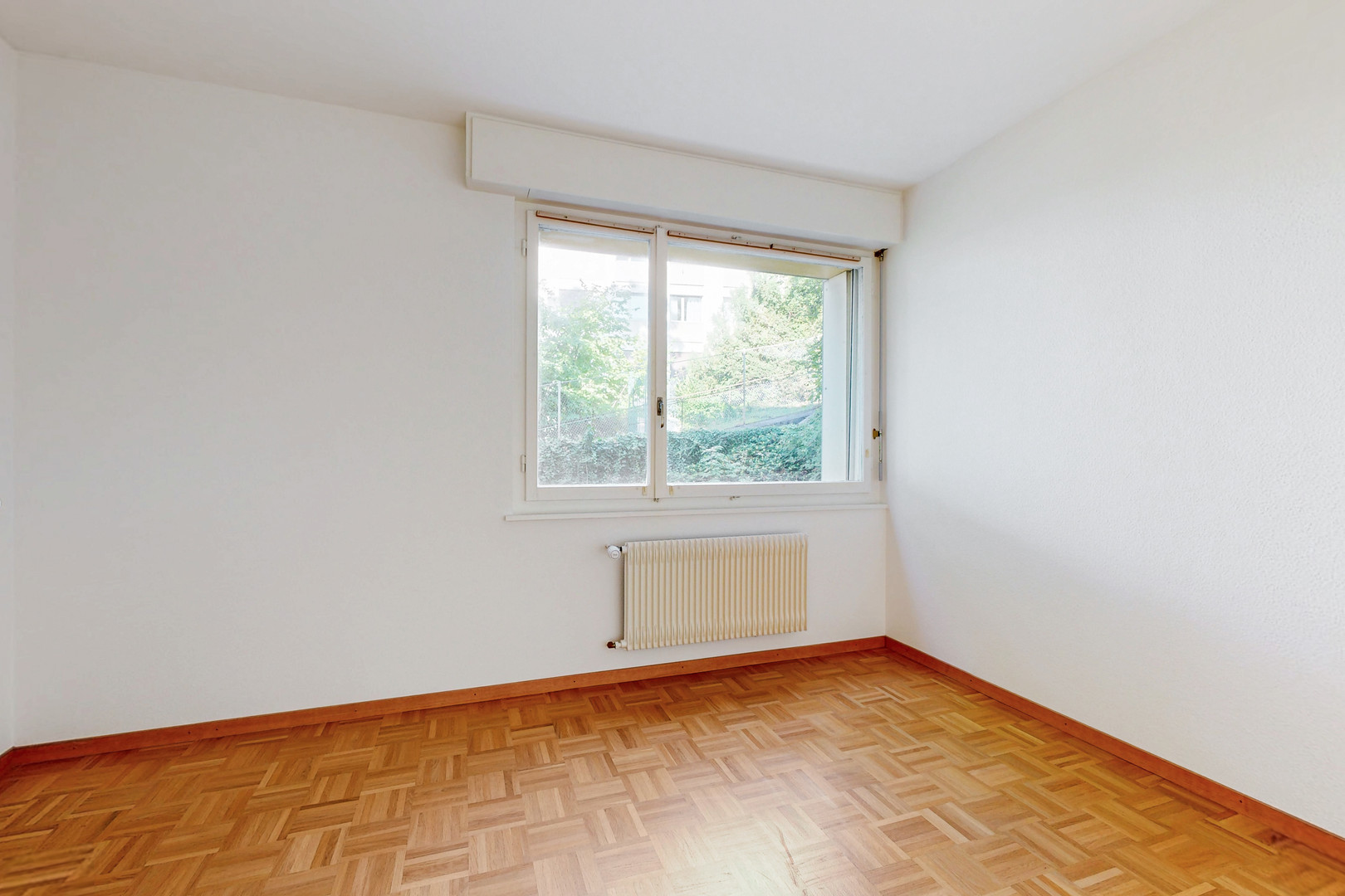 Helles leeres Zimmer mit Fenster und Heizkörper