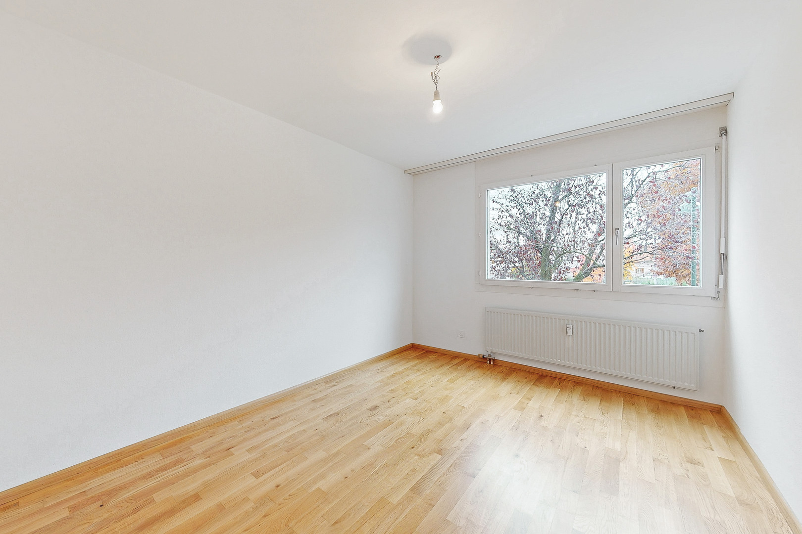 Leeres, helles Zimmer mit Parkettboden