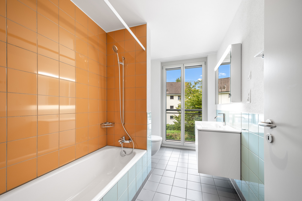 Modernes Badezimmer mit Badewanne und orangefarbenen Fliesen