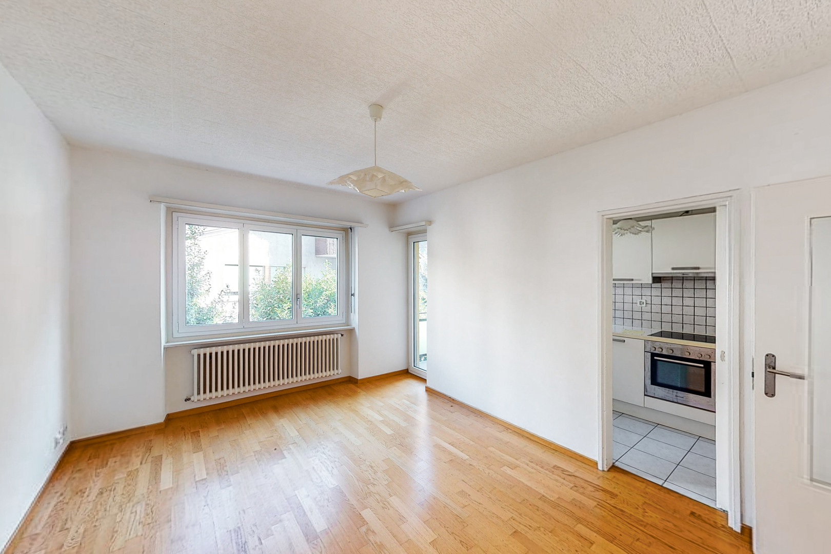 Heller leerer Wohnraum mit Blick in die Küche