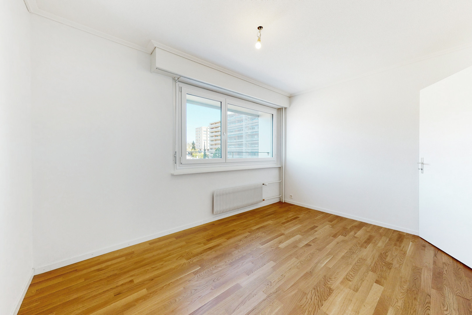 Helles, leeres Zimmer mit Parkettboden