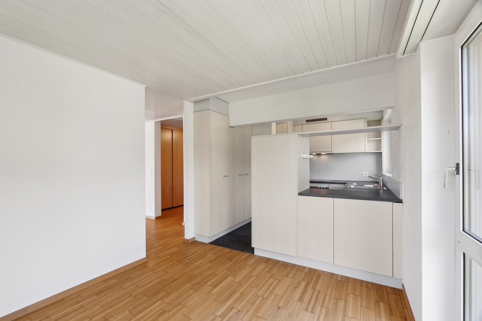 Kleine helle Küche mit Holzfußboden