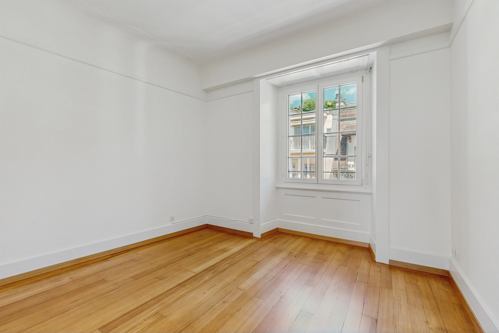 Helles leeres Zimmer mit Holzboden und Fenster