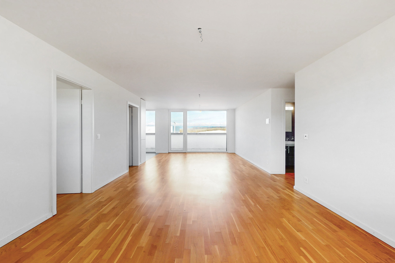 Leerer, heller Wohnraum mit Holzboden