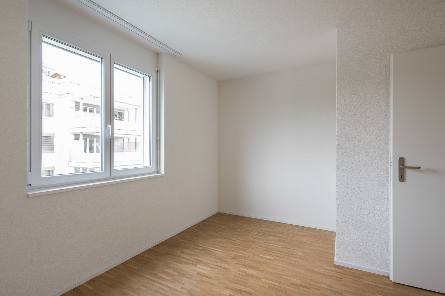Heller leerer Wohnraum mit Fenster und Tür