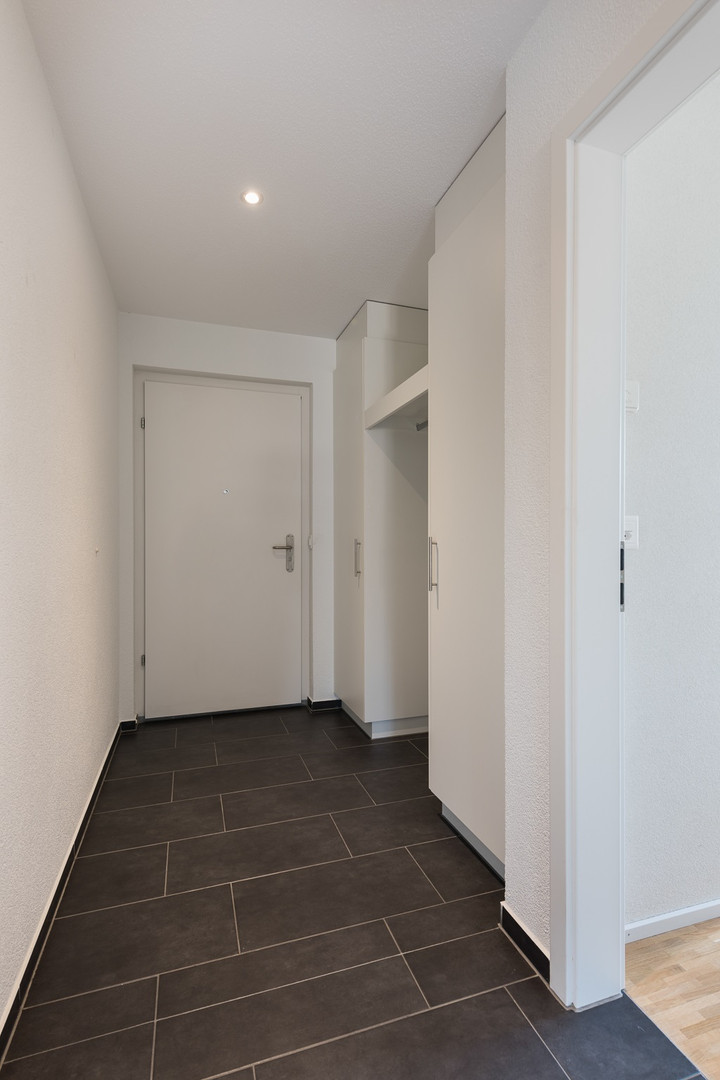 Flur mit Eingangstür und Garderobenschrank