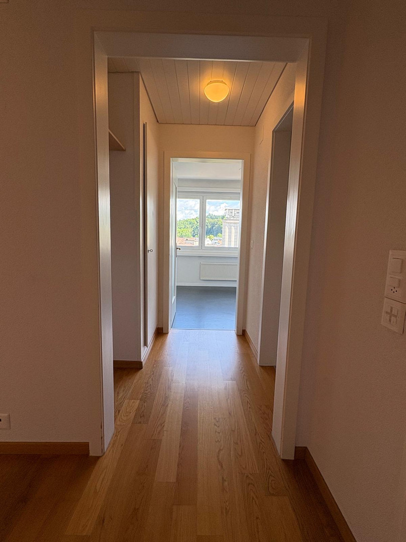 Heller Flur mit Blick in einen Raum mit Fenster