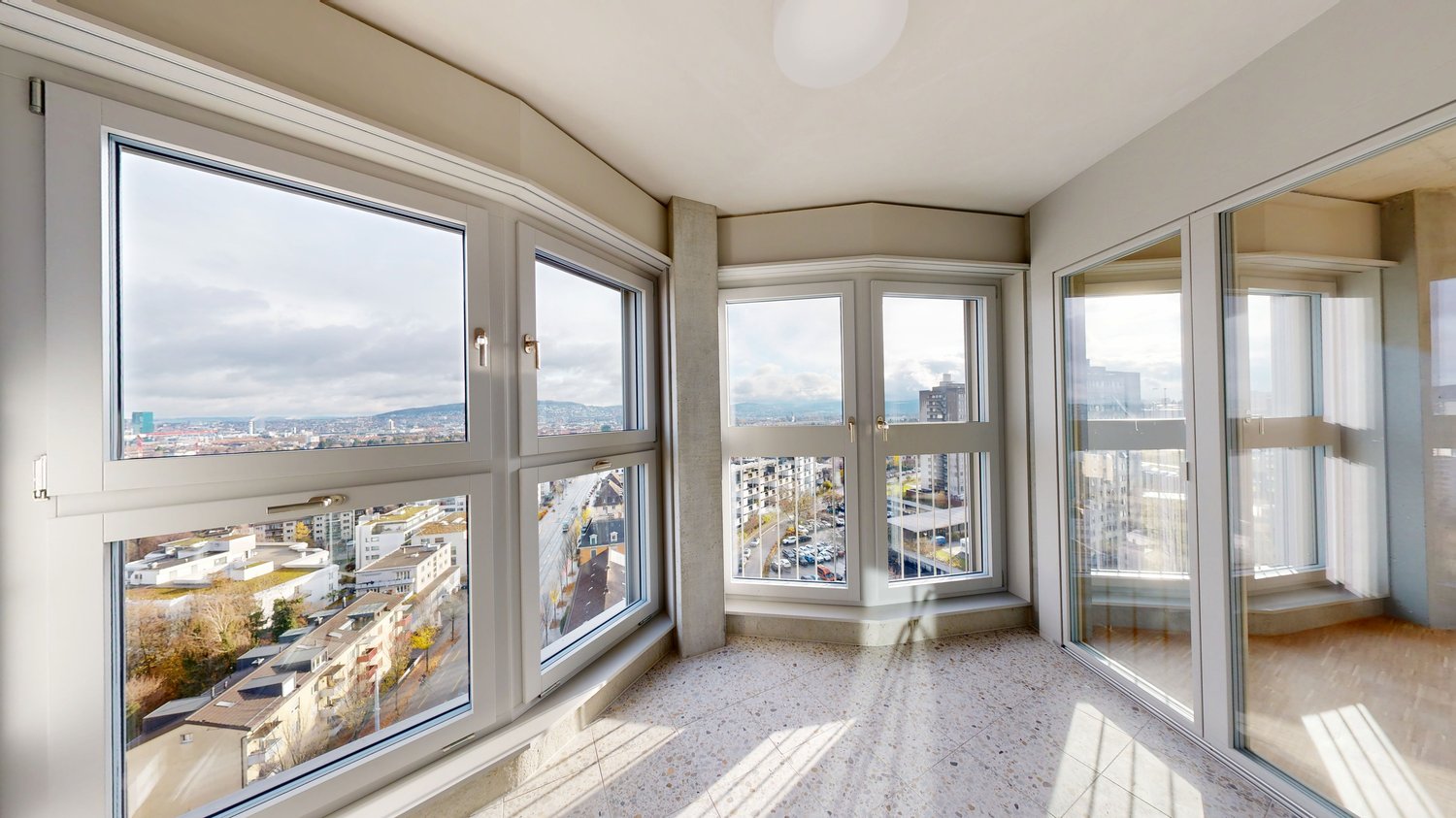 Helle verglaste Loggia mit Stadtblick