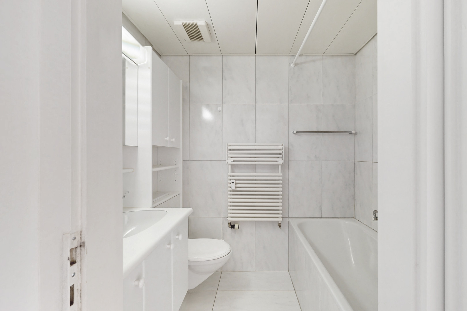 Kleines, helles Badezimmer mit Badewanne und WC