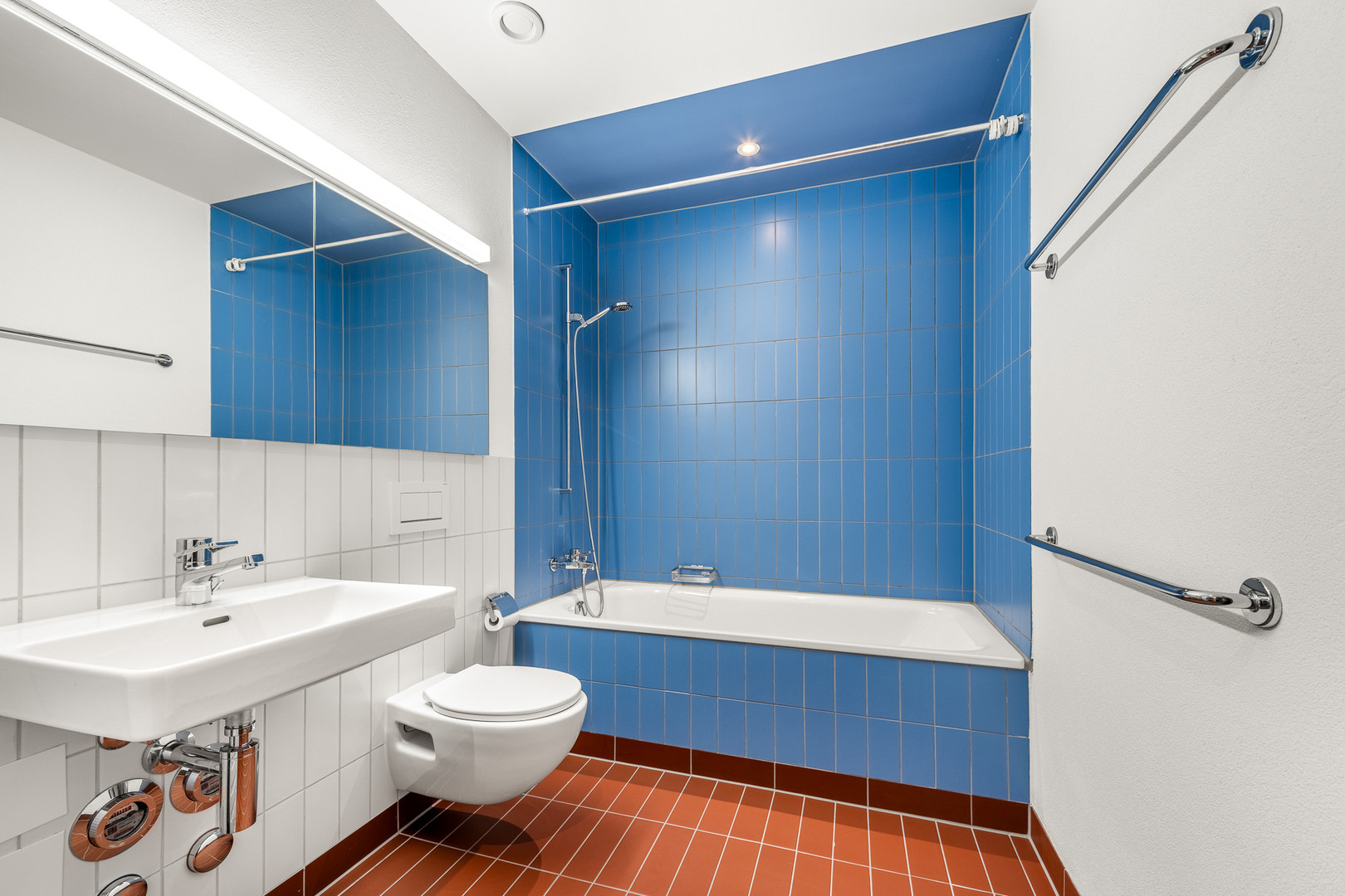 Modernes Badezimmer mit Badewanne und blau gefliester Dusche