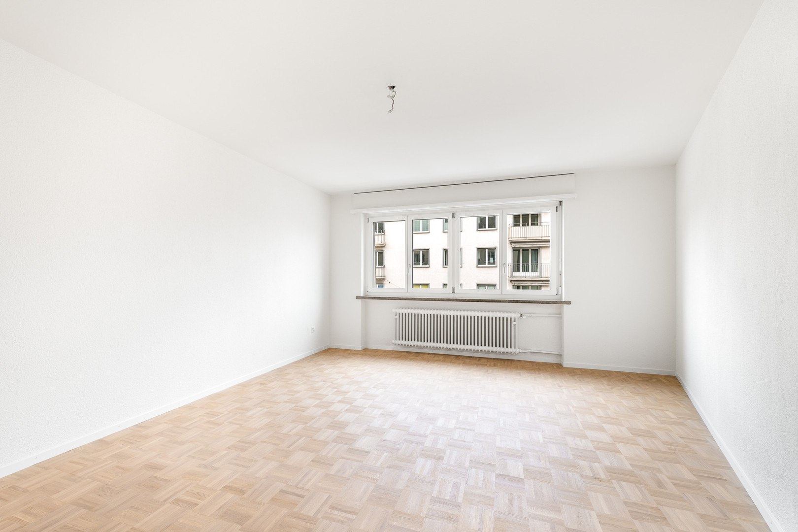 Heller leerer Wohnraum mit Fenster und Heizkörper