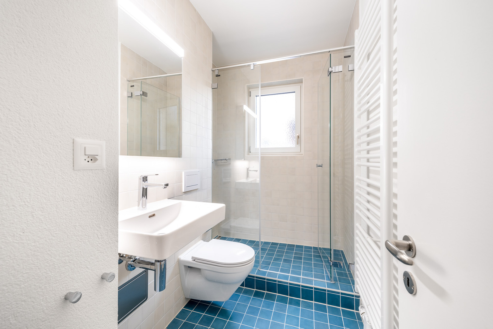 Helles Badezimmer mit blauen Bodenfliesen
