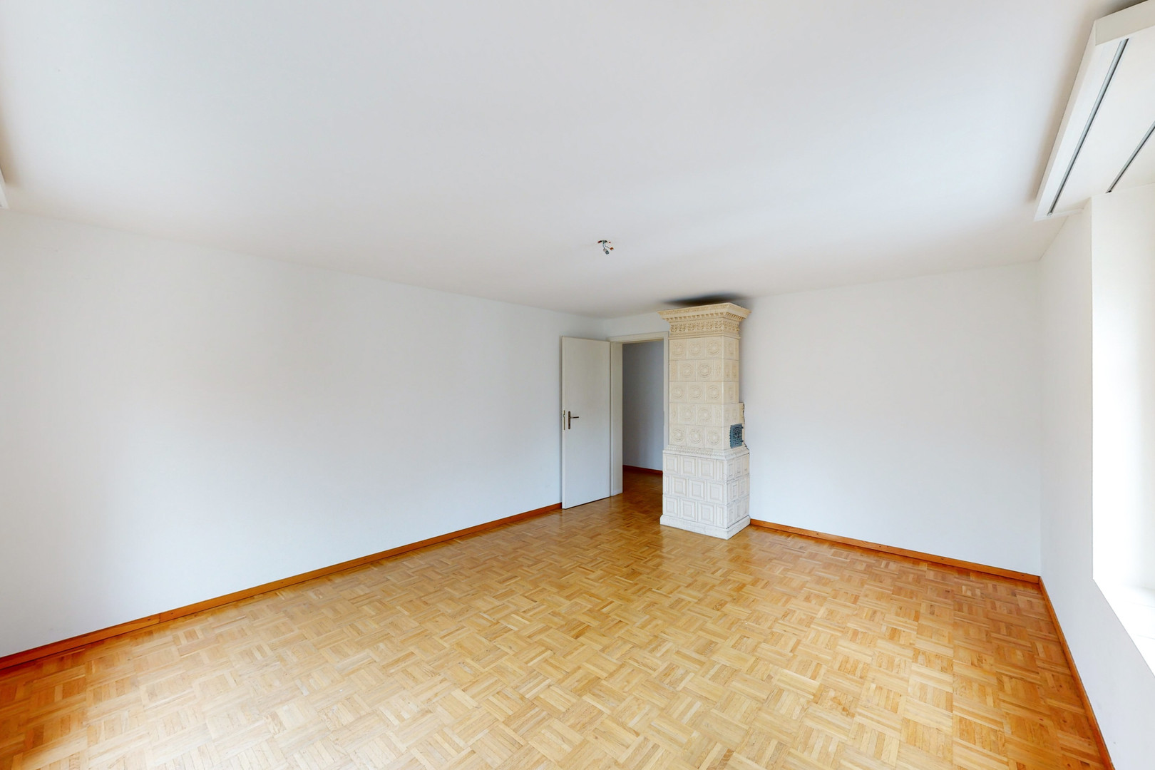 Leerer Wohnraum mit Kachelofen