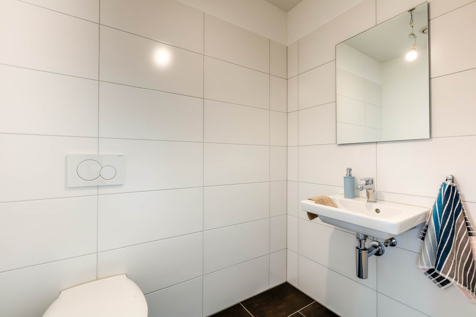 Modernes Gäste-WC mit Wandfliesen und Hängewaschbecken
