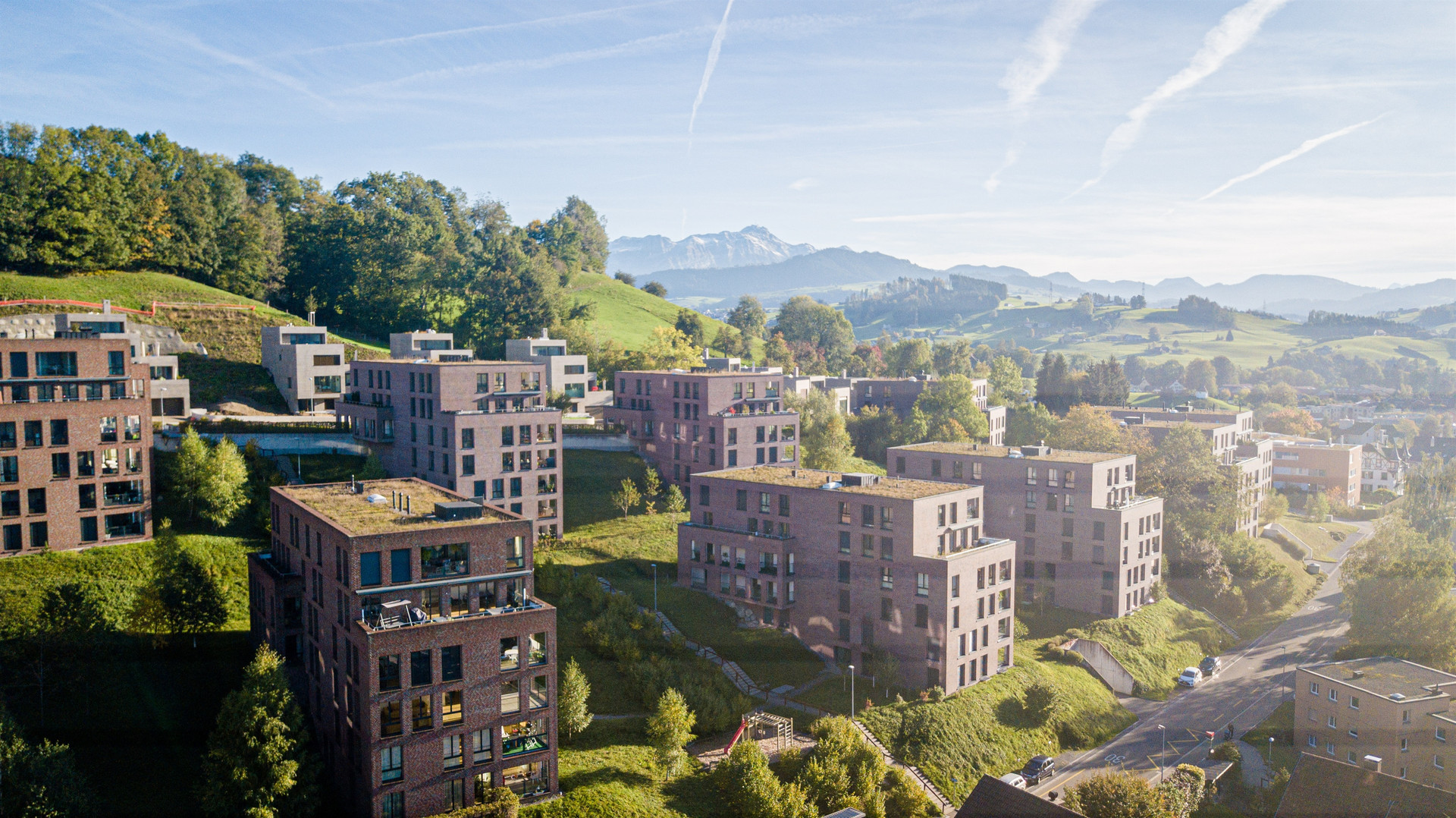Luftaufnahme einer modernen Wohnanlage in grüner Hügellandschaft