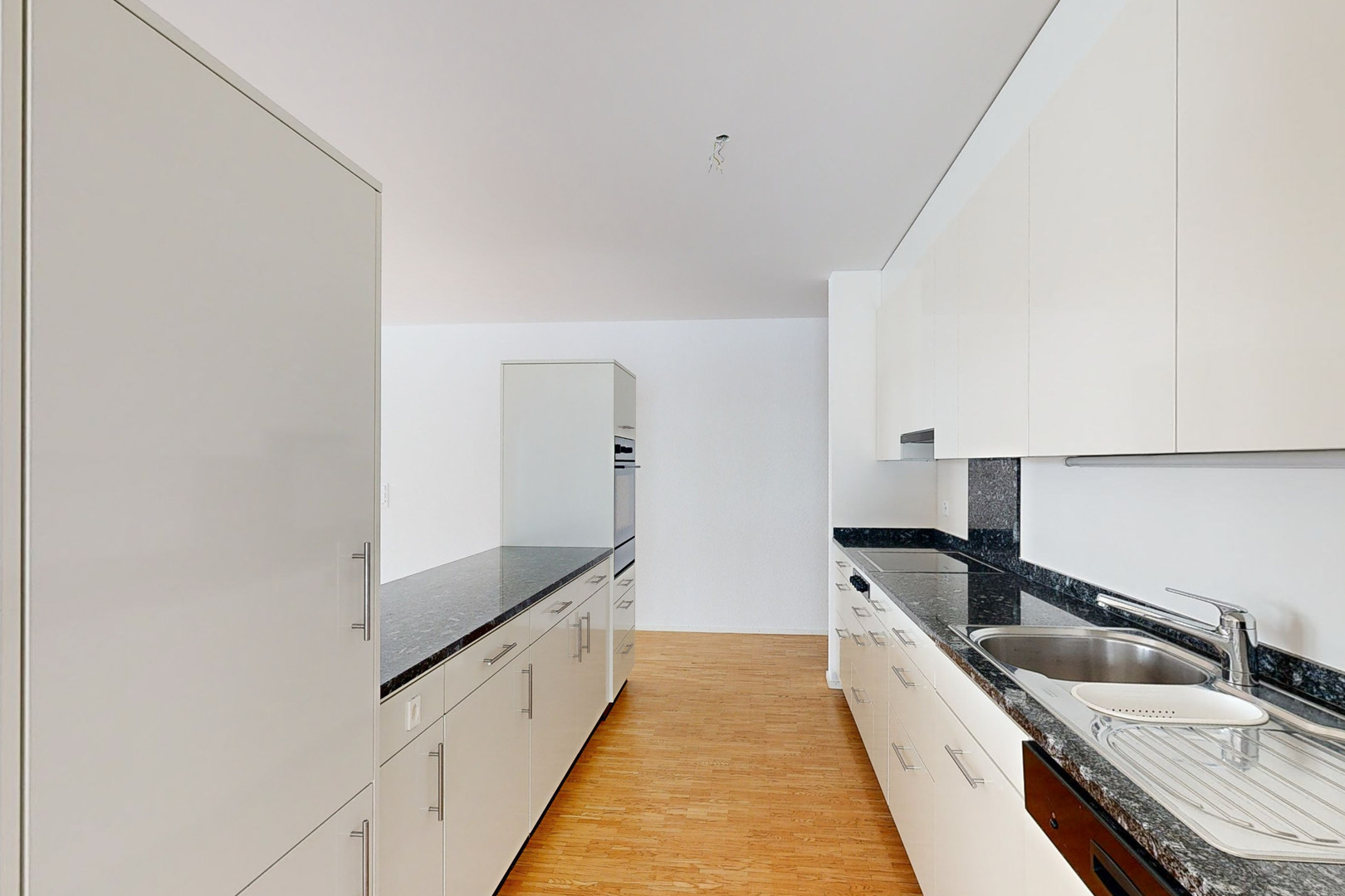 Moderne, schmale Küche mit weißem Ausbau