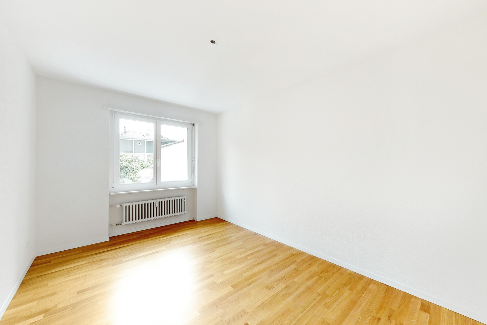 Helles leeres Zimmer mit Fenster und Heizkörper