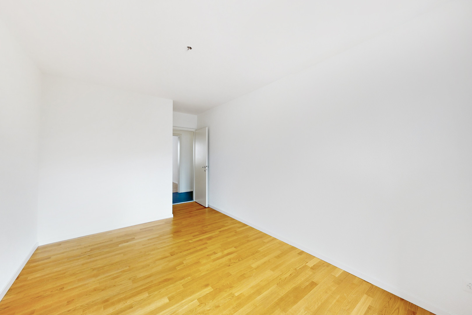 Leerer, frisch renovierter Raum mit Holzboden