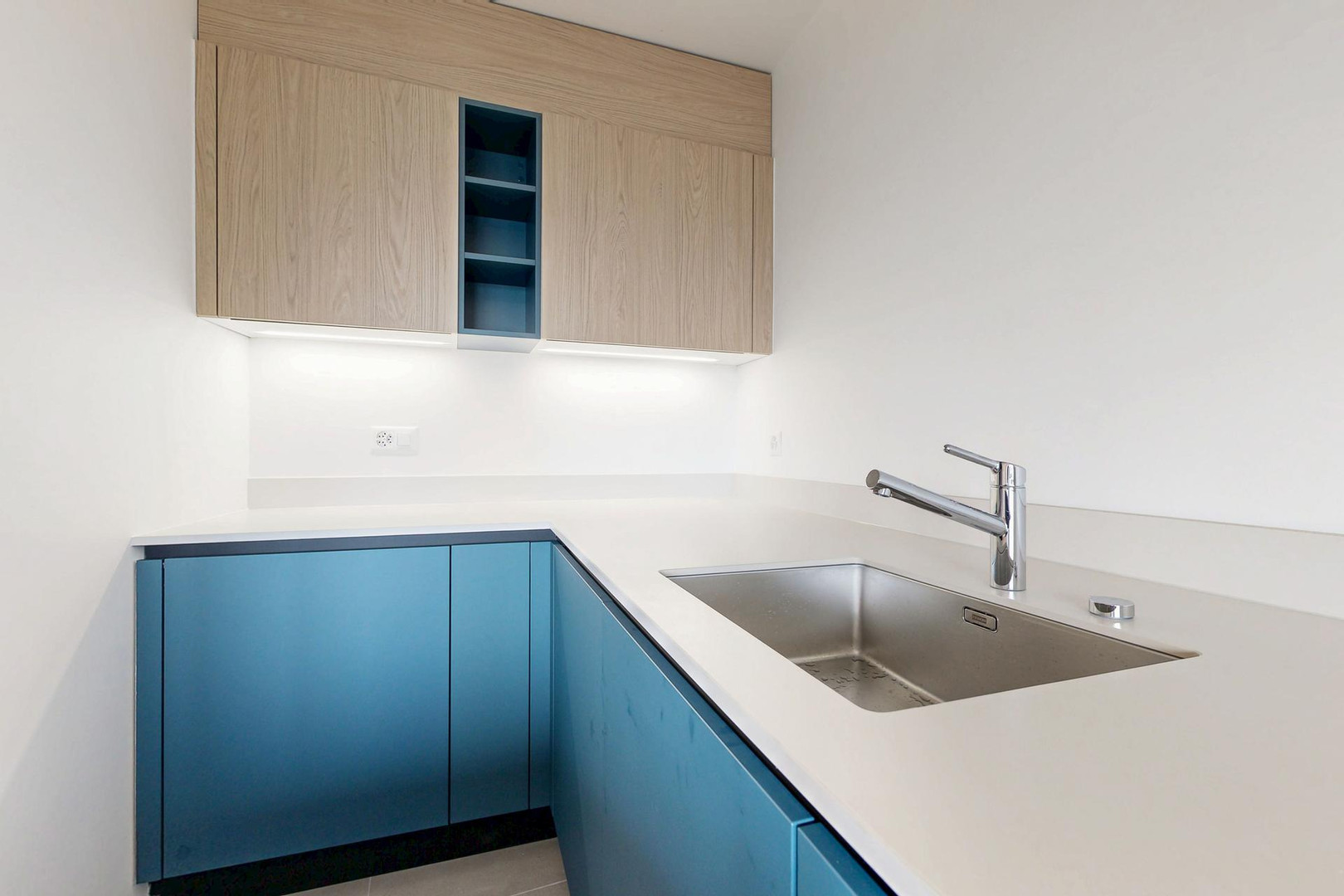 Moderne Küche mit blauem Unterschrank und Holzoberschrank