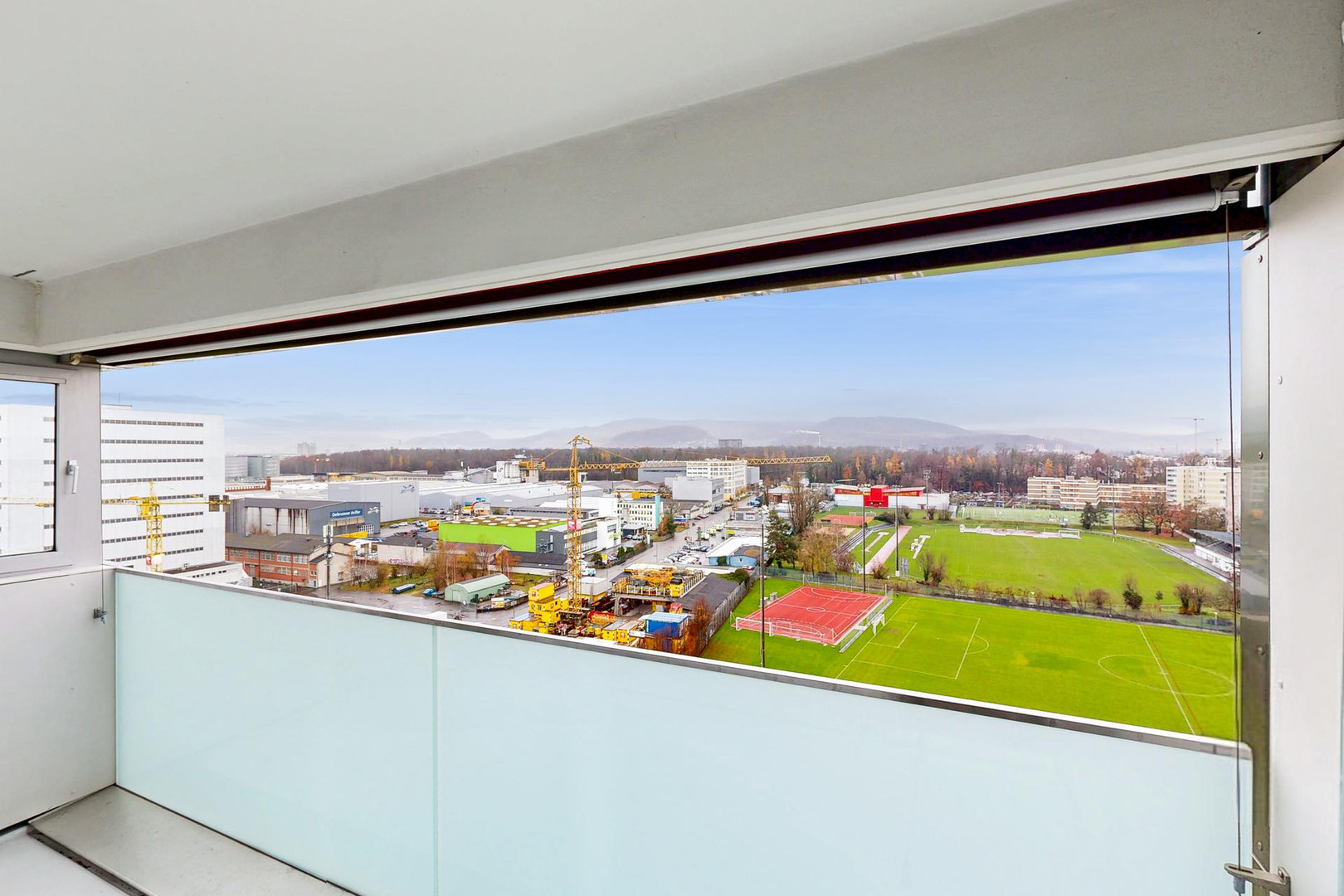 Balkon mit weitem Stadt- und Sportplatzblick