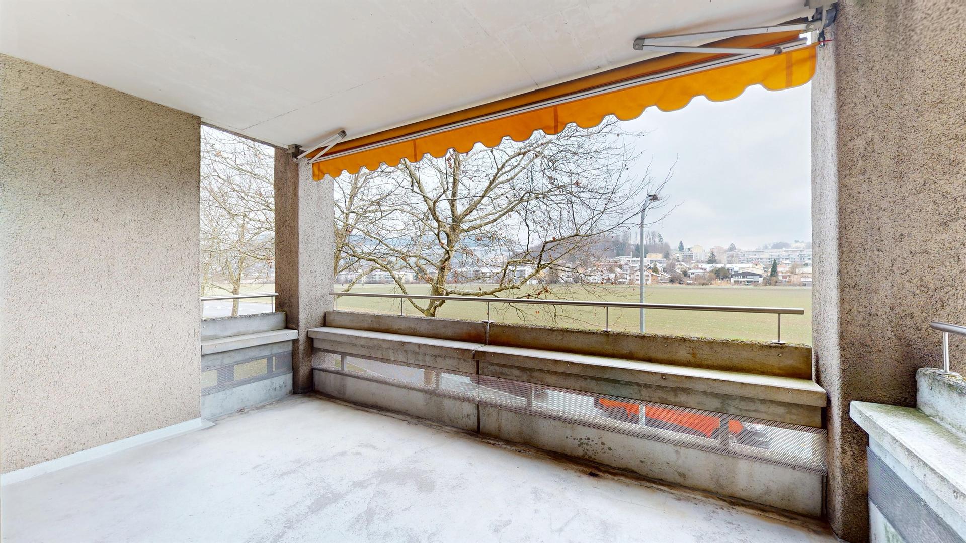 Überdachter Balkon mit Ausblick ins Grüne