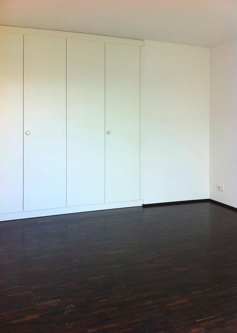 Helles, leeres Zimmer mit großem Einbauschrank