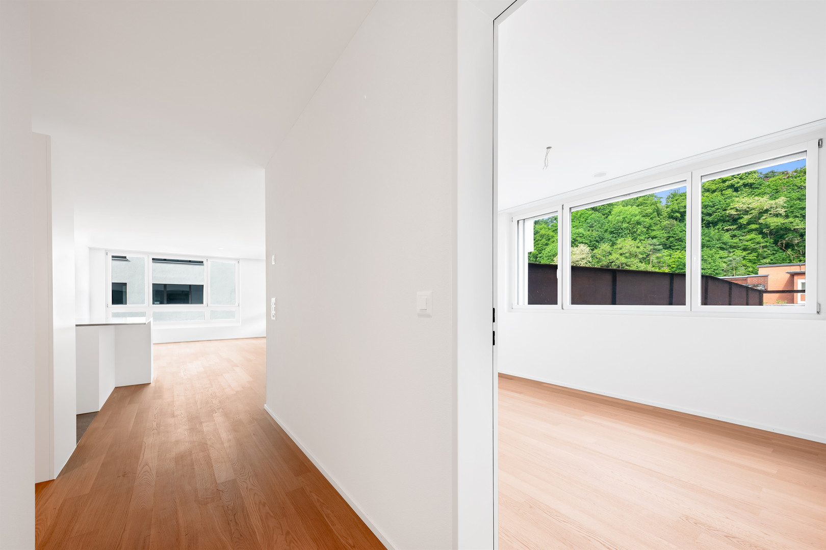Heller Flur mit Blick in einen Wohnraum